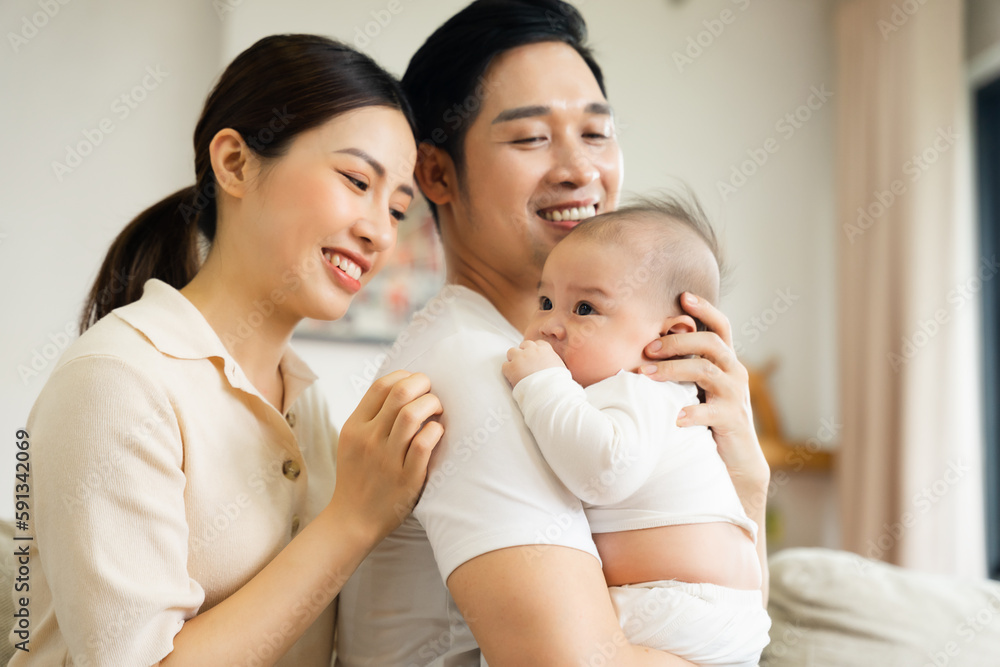 Smiling mother and father holding newborn son at home Smiling mother and father holding newborn son at home