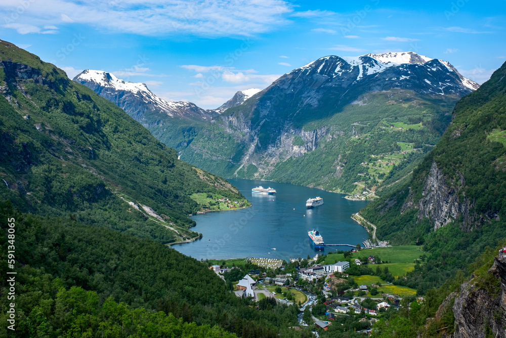 Views of Norwegian fjord landscape with snow mountains and  cruise ships in Geiranger fjord, Norway