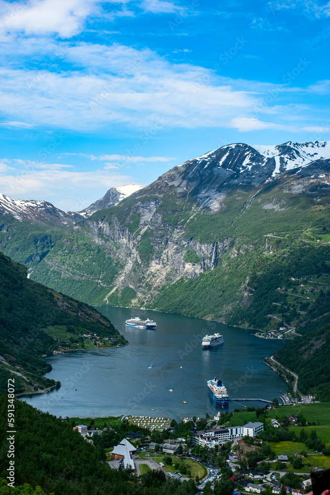 Views of Norwegian fjord landscape with snow mountains and  cruise ships in Geiranger fjord, Norway
