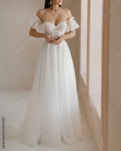 Fotografie Trendy classic long wedding dress with cleavage and wide short sleeves decorated with floral lace