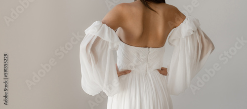 Gorgeous long wedding backless dress. Bride in the shoulderless white wedding dress with fancy sleeves