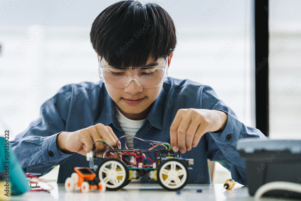 Asian teenager students doing robot arm and robotic cars homework ...