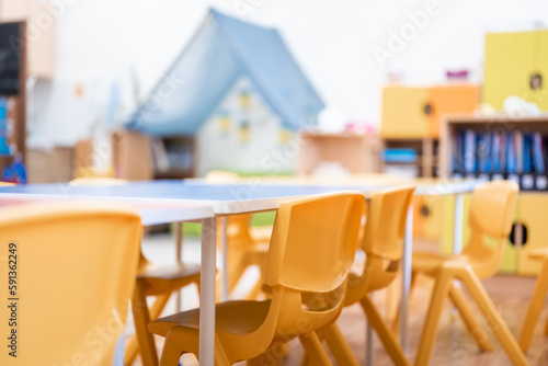 Fotografie Colorful kindergarten class without childs ,school education desk, chair, toy and decoration on background wall