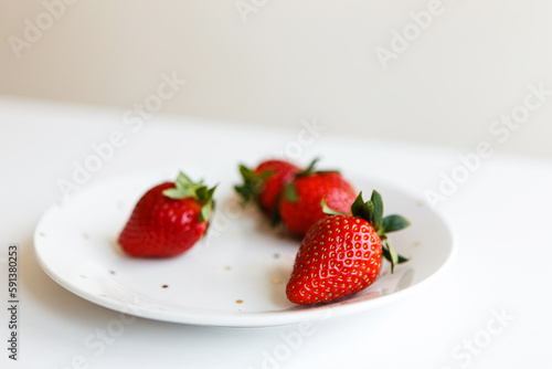 red ripe fresh strawberries on plate in kitchen before making dessert