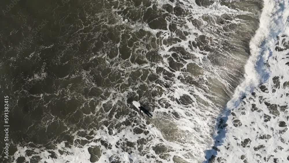 flying a drone over a surfer in the ocean flying a drone over a surfer in the ocean