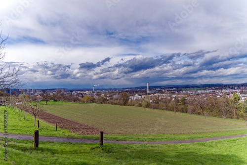 Scenic landscape with rural road at City of Zürich district Schwamendingen on a cloudy spring day. Photo taken March 31st, 2023, Zurich, Switzerland.