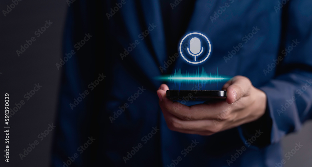 businessman using utilizes his smartphone as an AI assistant, effectively issuing voice commands through its microphone symbol, enhancing productivity with cutting-edge technology. - obrazy, fototapety, plakaty 