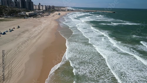Aerial view of beach shore with relaxing salty waves