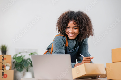 Startup small business entrepreneur SME, asian woman packing cloth in box. Portrait young Asian small business owner home office, online sell marketing delivery, SME e-commerce telemarketing concept. © wichayada