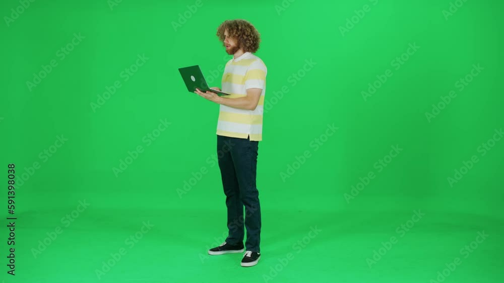 Focused user works on a laptop, a man with an afro hairstyle typing on a laptop on the go, green background, chroma key template. Focused user works on a laptop, a man with an afro hairstyle typing on a laptop on the go, green background, chroma key template.