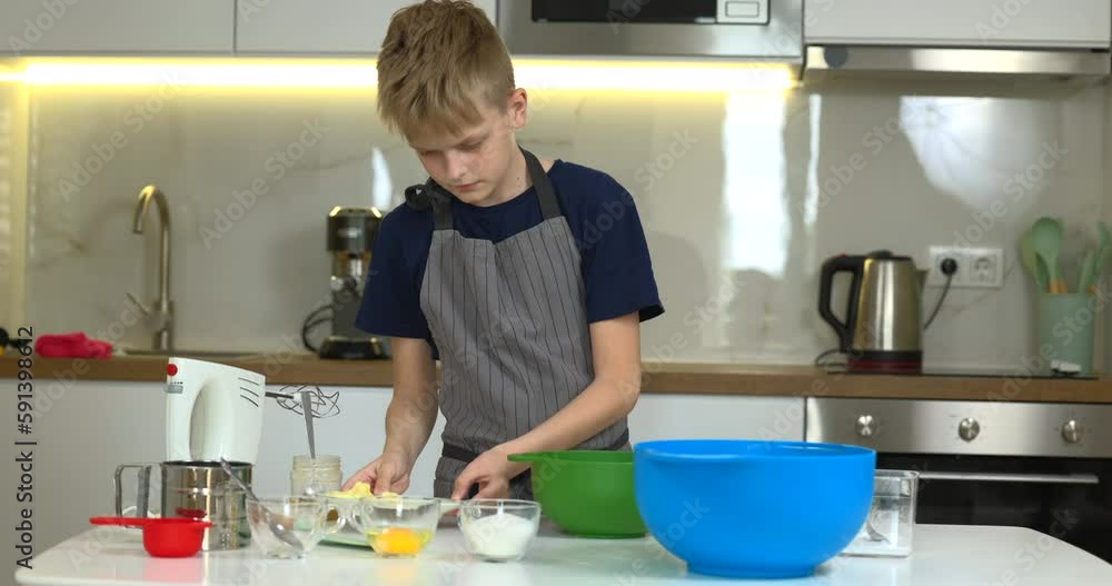 Young boy preparing dough for cookies on the kitchen alone. Young boy preparing dough for cookies on the kitchen alone.