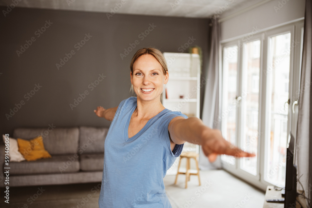 Young blonde woman practicing yoga in her apartment and smiling at the camera Young blonde woman practicing yoga in her apartment and smiling at the camera