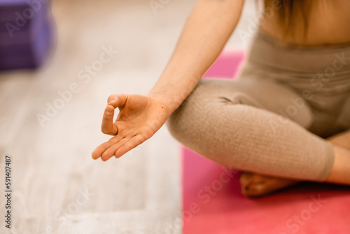 Girl does yoga. Young woman practices asanas on a beige one-ton background.