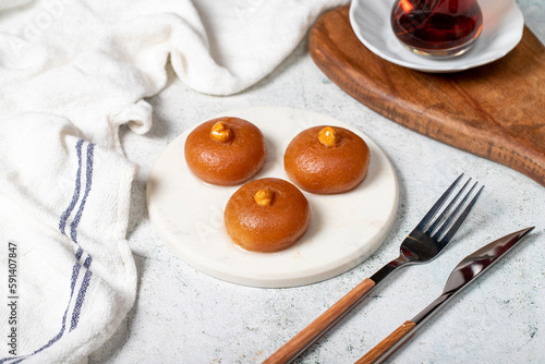 Sekerpare dessert. Turkish Ramadan dessert. Sekerpare dessert with sherbet on a marble serving plate photo