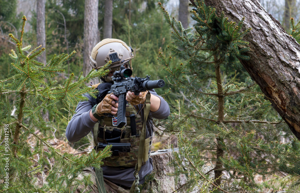 A soldier with a machine gun is ready to fire at the target.