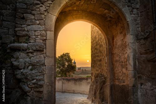 Foto Sun at dawn through the Puerta de Santiago de Trujillo, Cáceres, Spain