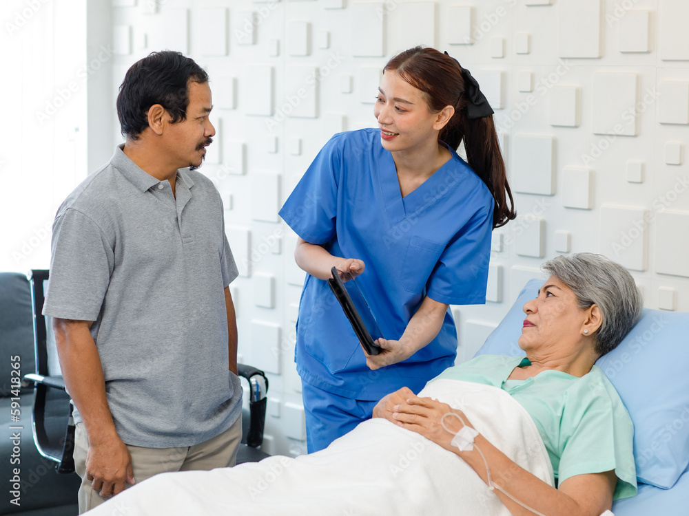 Obraz premium Asian professional successful female assistant internship nurse in blue uniform holding tablet computer visiting discussing showing diagnosis information to old senior unhealthy patient in ward