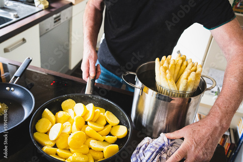 old man cooking asparagus in the kitchen