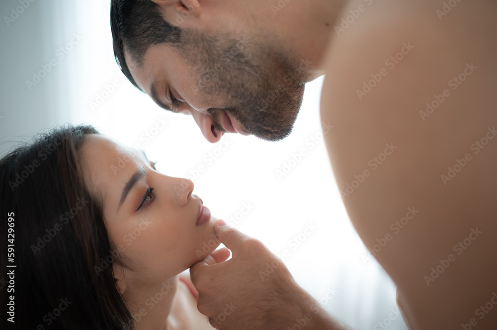 Fototapeta premium Gorgeous sexy couple enjoying arousing sex before having sex on bed in home bedroom The concept of emotional and love relationships.