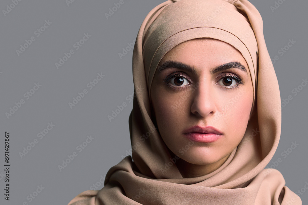 Headshot of a young woman in beige hijab Headshot of a young woman in beige hijab