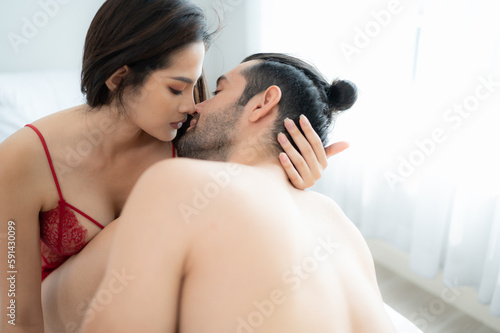 Obraz na plátně Gorgeous sexy couple enjoying erotic arousal by the man touching and caressing the woman's legs Before the two had sex on the bed