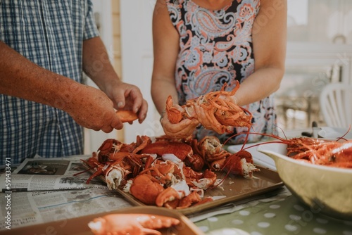 Senior man and woman cleaning fresh delicious clambakes in the kitchen photo