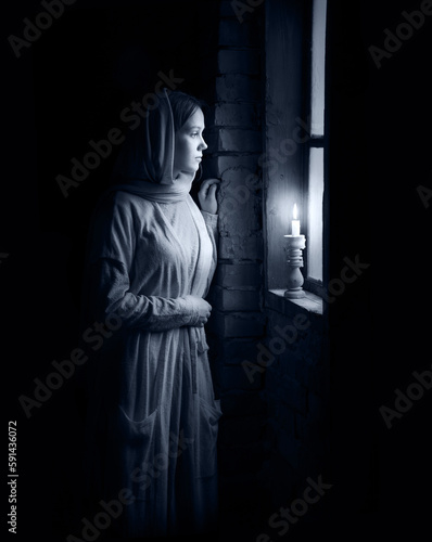 Young girl at the old wooden window