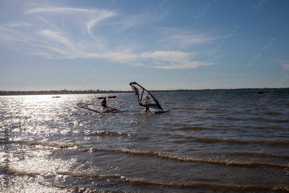 Naklejka premium Surfers on the surface of a wavy sea in a sunny day