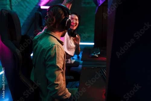 Team of gamers giving high five to each other while playing video game on championship in cybersport club