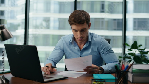 Portrait surprised businessman reading great news in documents working on laptop