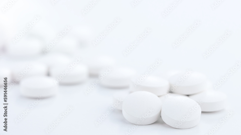 White tablets scattered on the pharmaceutical table White tablets scattered on the pharmaceutical table