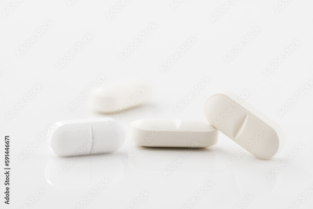 Medical pills close up. White pills, white background. Concept of healthcare and medicine. Medical pills close up. White pills, white background. Concept of healthcare and medicine.