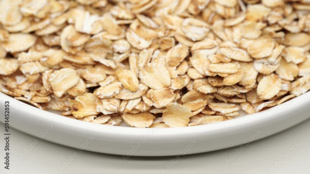 Uncooked oatmeal flakes texture close up. Rotation. Pile of uncooked