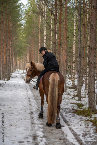 Woman horseback riding in forest