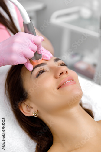 Cosmetology service,Facial treatment,esthetic procedure,Rejuvenation treatment. cosmetologist is administering a cosmetic facial procedure to a female client