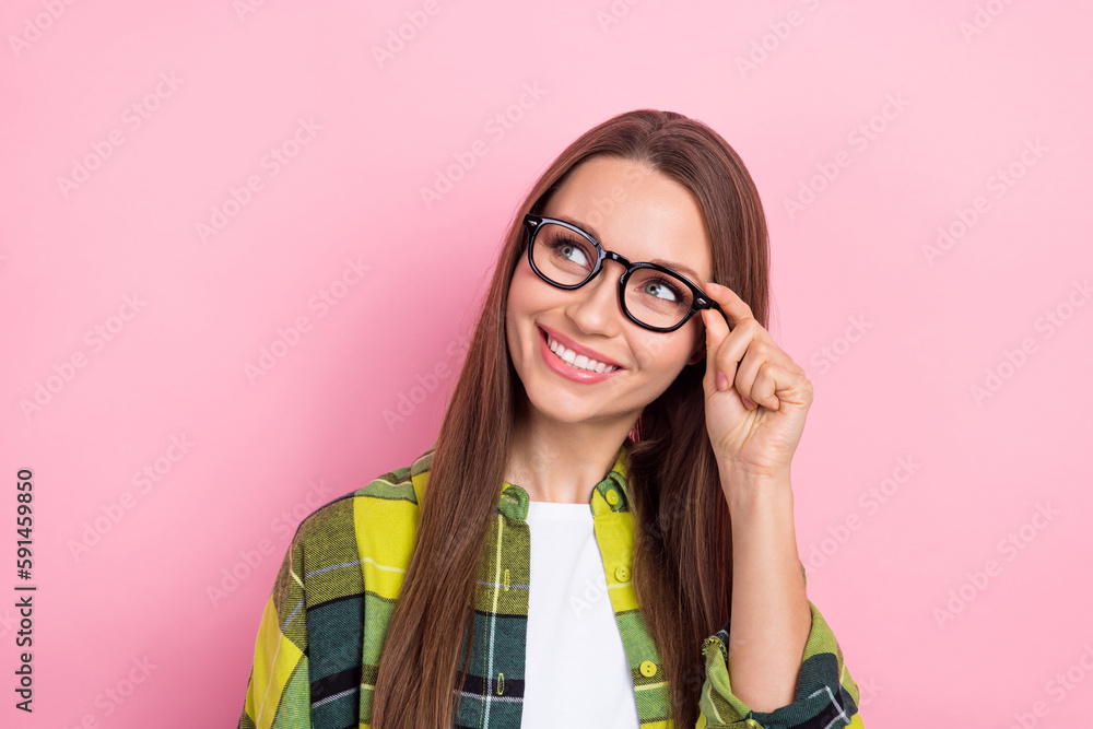 Photo of pretty cheerful person hand touch glasses beaming smile look empty space isolated on pink color background