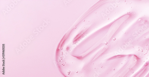 Serum gel smear on pink background. Cosmetic transparent gel serum texture.