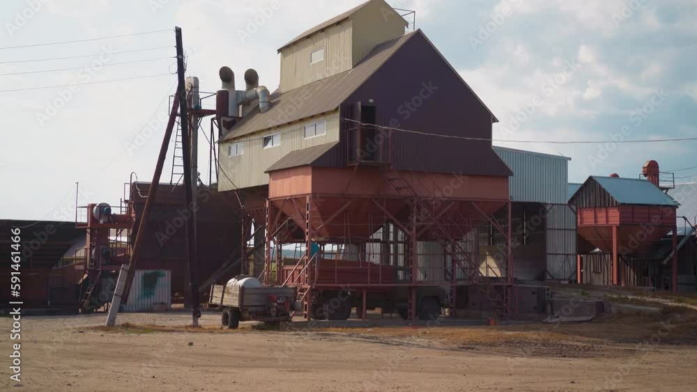 Loading grains into truck body from funnel near granary building at countryside. Wheat harvest transportation and sorting process. Agricultural industry Loading grains into truck body from funnel near granary building at countryside. Wheat harvest transportation and sorting process. Agricultural industry