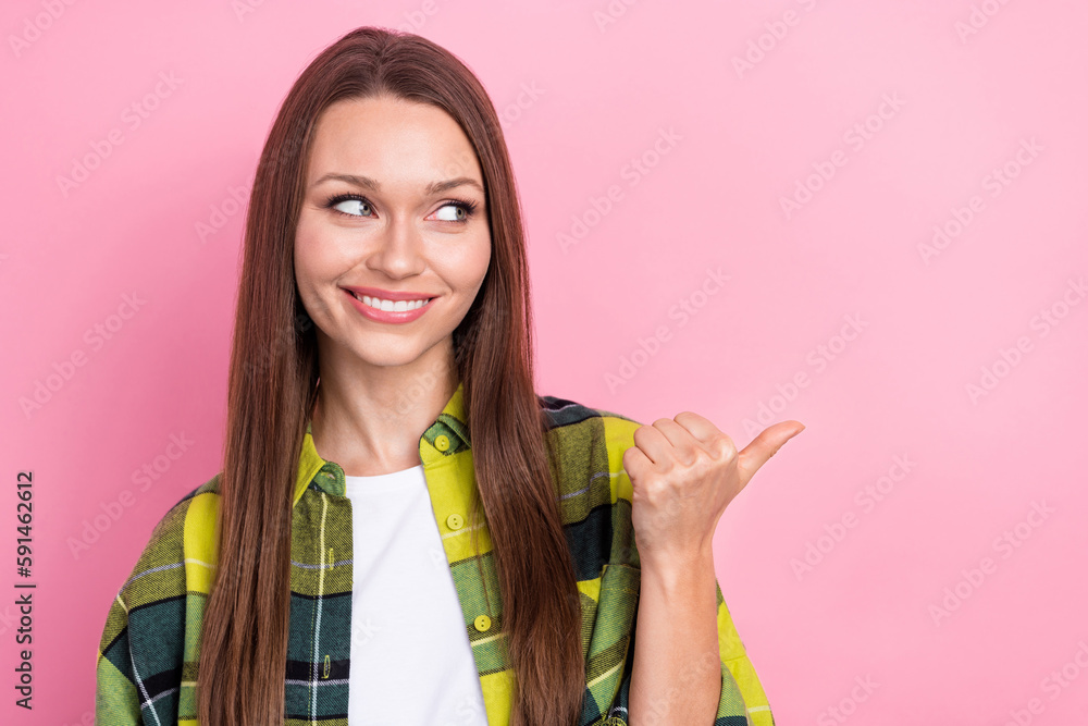 Portrait of young happy girl wear plaid shirt looking directing finger empty space open new clothes brand shopping isolated on pink color background Portrait of young happy girl wear plaid shirt looking directing finger empty space open new clothes brand shopping isolated on pink color background