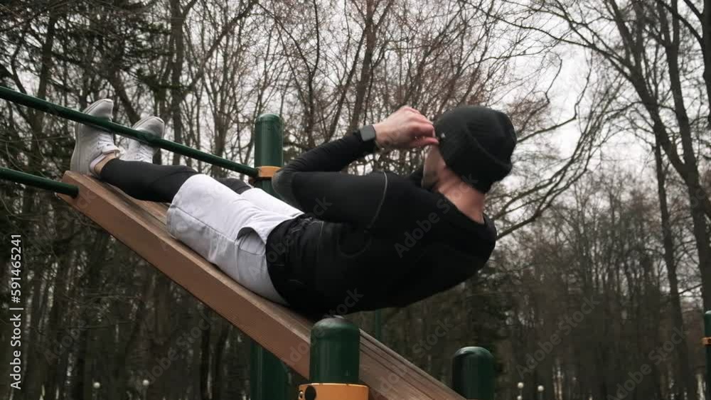 a guy performs a press exercise on a sports field on the street, a man does sports, slow motion a guy performs a press exercise on a sports field on the street, a man does sports, slow motion