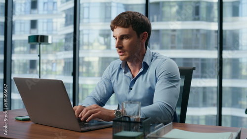 Serious boss answering call office interior closeup. Businessman typing laptop