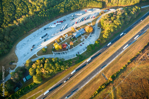 Aerial view of big rest area near busy american freeway with fast moving cars and trucks. Recreational place during interstate travel concept