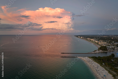 Aerial view of Nokomis beach and South and North Jetty in Sarasota County, USA. Many people enjoing vacation time swimming in gulf water and relaxing on warm Florida sun at sunset
