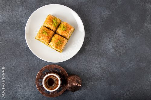 Traditional pistachio baklava with Turkish coffee on black background,top view