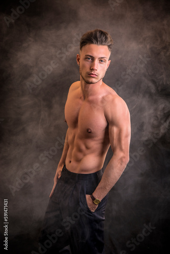 Handsome shirtless athletic young man in studio shot