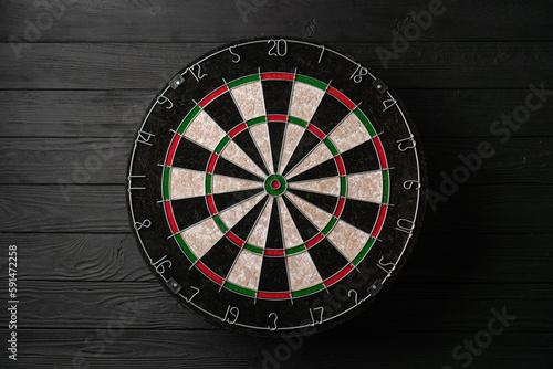 Tableau sur toile New classic professional sisal dart board on black wooden background