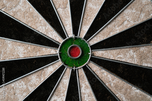 New classic professional sisal dart board on black wooden background. Close up.