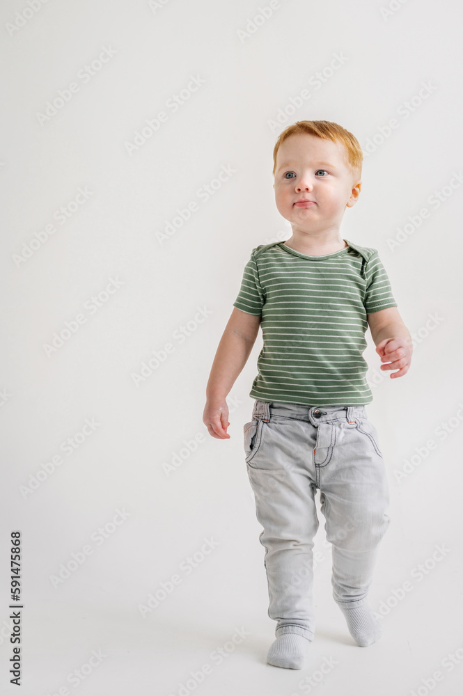 Adorable toddler boy playing and standing at home, having fun isolated on white background studio, copy space. Child play and smile. Little kid standing on floor in sunny room. Closeup. Place for text Adorable toddler boy playing and standing at home, having fun isolated on white background studio, copy space. Child play and smile. Little kid standing on floor in sunny room. Closeup. Place for text