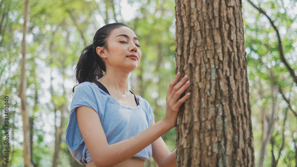 Female is touching a trunk of a tree, concept of feel the nature. Connected to nature or earth. Environmental saving and peaceful, greenery and spiritual warm moment. Freedom, sustainability, protect. Female is touching a trunk of a tree, concept of feel the nature. Connected to nature or earth. Environmental saving and peaceful, greenery and spiritual warm moment. Freedom, sustainability, protect.