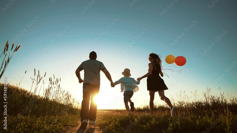 Active happy family run together on wheat field. Enjoy summer walk in nature. Mom hold balloons in hands, dad and boy spread arms to sides and feeling freedom. Tourism, travel, hike. Leisure activity. Active happy family run together on wheat field. Enjoy summer walk in nature. Mom hold balloons in hands, dad and boy spread arms to sides and feeling freedom. Tourism, travel, hike. Leisure activity.